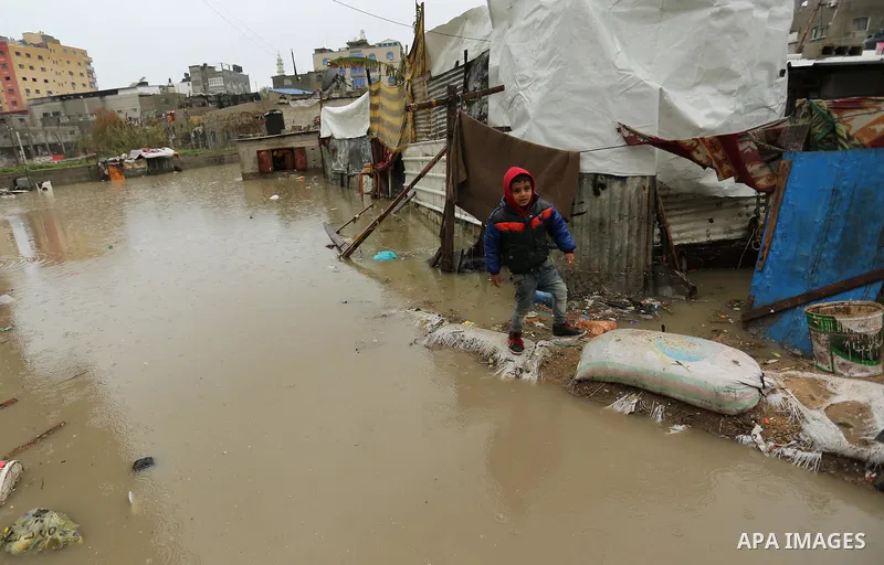 A Palestinian boys walks through flood water following heavy rain in a neighbourhood in the northern Gaza Strip February 16, 2017. Photo by Ashraf Amra