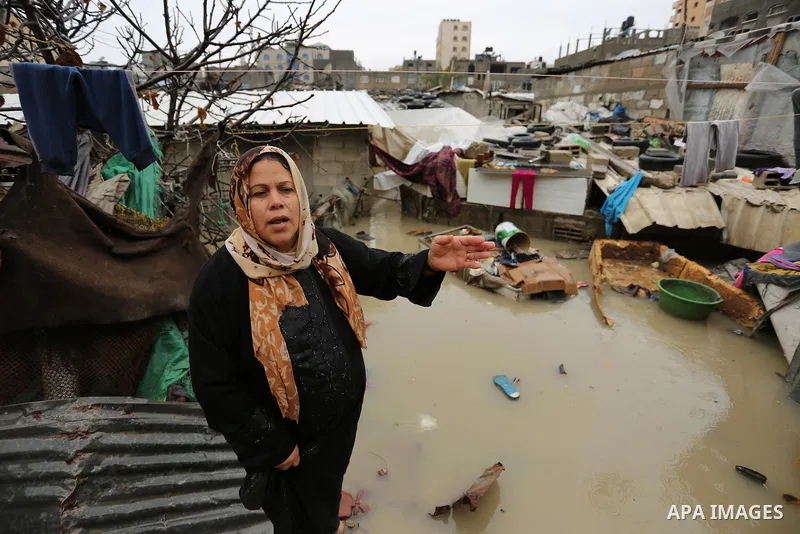 A Palestinian woman asks for help after her house was flooded following heavy rain in a neighbourhood in the northern Gaza Strip February 16, 2017. Photo by Ashraf Amra