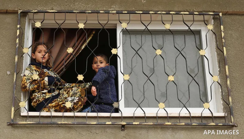 Palestinians look out their family house following heavy rain in a neighbourhood in the northern Gaza Strip February 16, 2017. Photo by Ashraf Amra