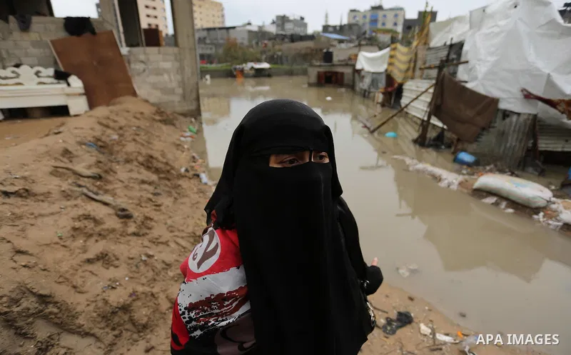 A Palestinian woman asks for help after her house was flooded following heavy rain in a neighbourhood in the northern Gaza Strip February 16, 2017. Photo by Ashraf Amra