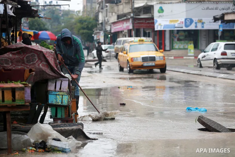 Palestinians stand outside their houses following heavy rain in a neighbourhood in the northern Gaza Strip February 16, 2017. Photo by Mohammed Asad