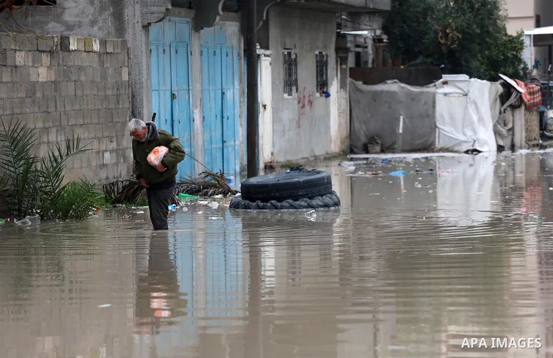 A Palestinian man walks through flood water following heavy rain in a neighbourhood in the northern Gaza Strip February 16, 2017. Photo by Mohammed Asad