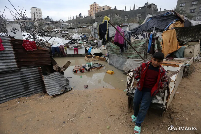 A Palestinian boy stands outside his family house following heavy rain in a neighbourhood in the northern Gaza Strip February 16, 2017. Photo by Mohammed Asad