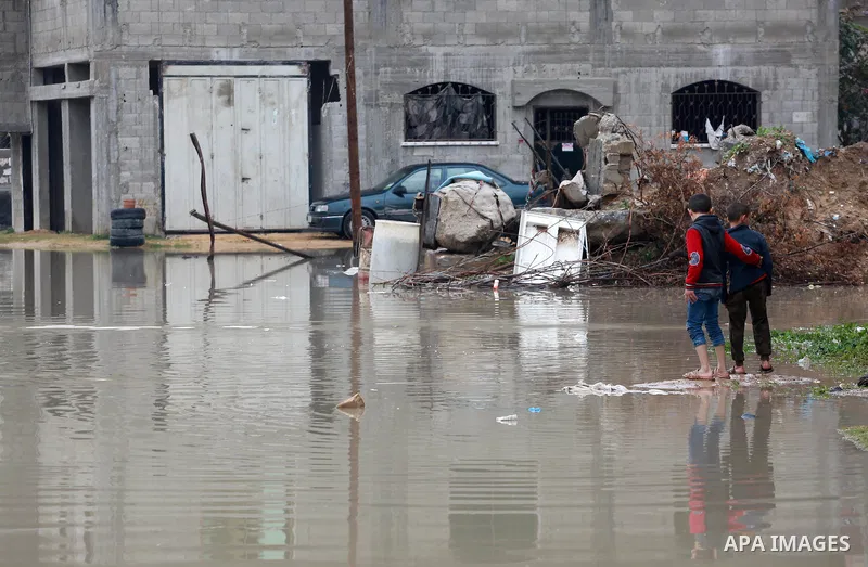 Palestinian child stand outside their family houses following heavy rain in a neighbourhood in the northern Gaza Strip February 16, 2017. Photo by Mohammed Asad