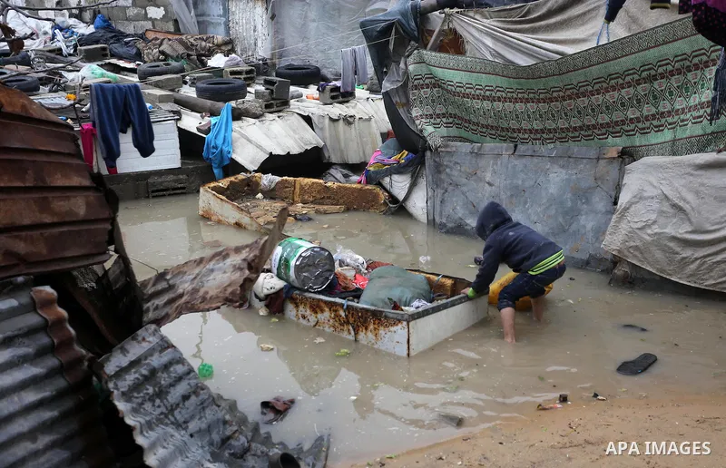 A Palestinian boy pulls his family belongings following heavy rain in a neighbourhood in the northern Gaza Strip February 16, 2017. Photo by Mohammed Asad