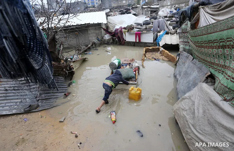 A Palestinian boy pulls his family belongings following heavy rain in a neighbourhood in the northern Gaza Strip February 16, 2017. Photo by Mohammed Asad