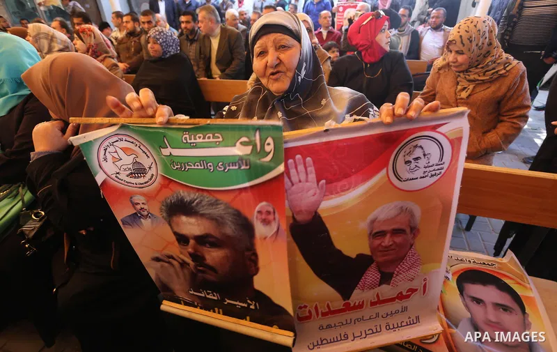 Palestinians hold placards during a protest to show solidarity with Palestinian prisoners held in Israeli Jails, in front of Red cross office in Gaza city, on February 20, 2017. Photo by Mohammed Asad