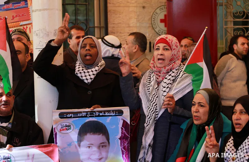 Palestinians hold placards during a protest to show solidarity with Palestinian prisoners held in Israeli Jails, in front of Red cross office in Gaza city, on February 20, 2017. Photo by Mohammed Asad