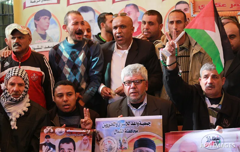 Palestinians hold placards during a protest to show solidarity with Palestinian prisoners held in Israeli Jails, in front of Red cross office in Gaza city, on February 20, 2017. Photo by Mohammed Asad