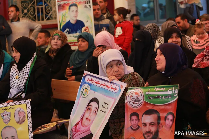 Palestinians hold placards during a protest to show solidarity with Palestinian prisoners held in Israeli Jails, in front of Red cross office in Gaza city, on February 20, 2017. Photo by Mohammed Asad