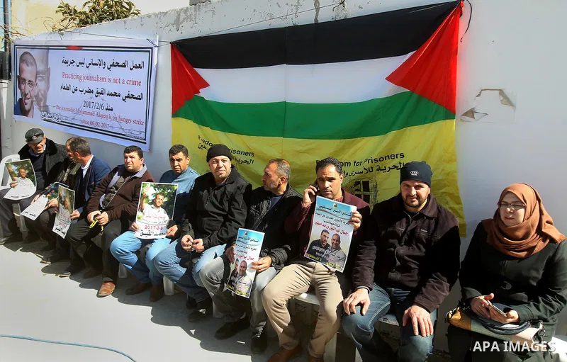 Palestinians hold placards during a protest to show solidarity with Palestinian prisoners held in Israeli Jails, in the West Bank city of Hebron, on February 20 2017. Photo by Wisam Hashlamoun