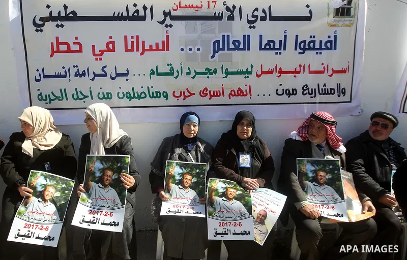 Palestinians hold placards during a protest to show solidarity with Palestinian prisoners held in Israeli Jails, in the West Bank city of Hebron, on February 20 2017. Photo by Wisam Hashlamoun