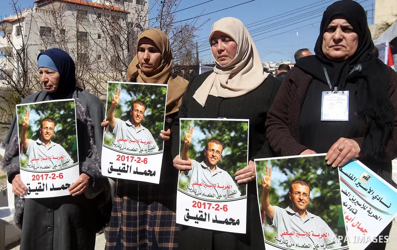 Palestinians hold placards during a protest to show solidarity with Palestinian prisoners held in Israeli Jails, in the West Bank city of Hebron, on February 20 2017. Photo by Wisam Hashlamoun