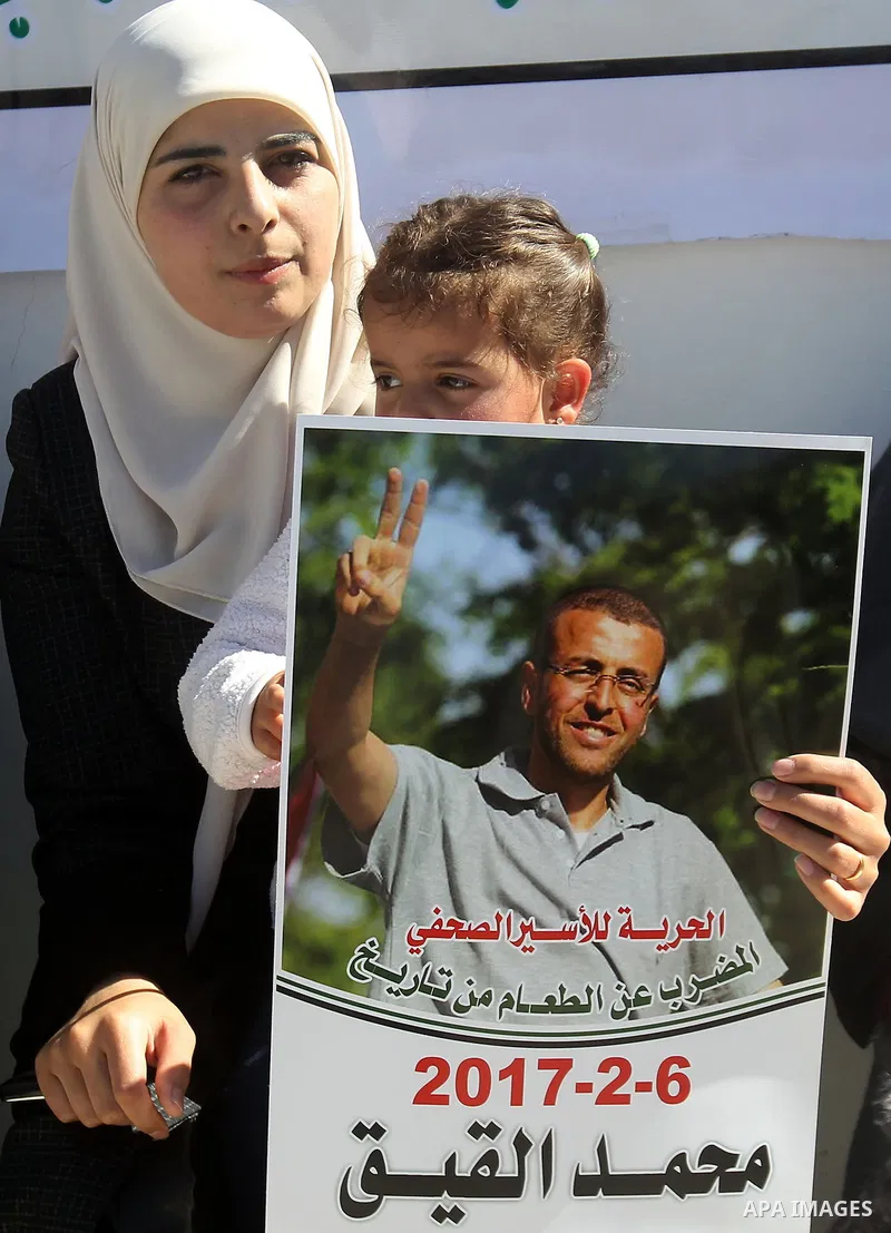 Palestinians hold placards during a protest to show solidarity with Palestinian prisoners held in Israeli Jails, in the West Bank city of Hebron, on February 20 2017. Photo by Wisam Hashlamoun