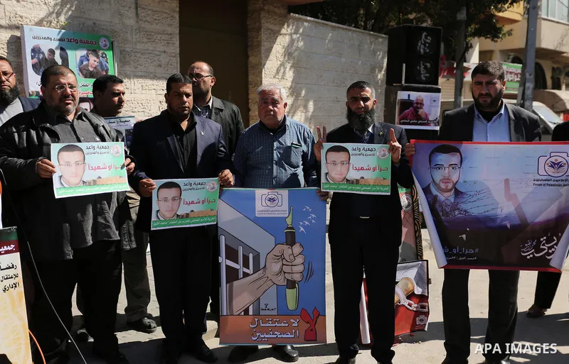 Palestinians hold placards during a protest to show solidarity with Palestinian prisoners held in Israeli Jails, in front of Red cross office in Gaza city, on February 21, 2017. Photo by Ashraf Amra