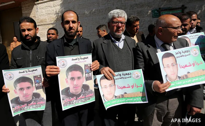 Palestinians hold placards during a protest to show solidarity with Palestinian prisoners held in Israeli Jails, in front of Red cross office in Gaza city, on February 21, 2017. Photo by Ashraf Amra
