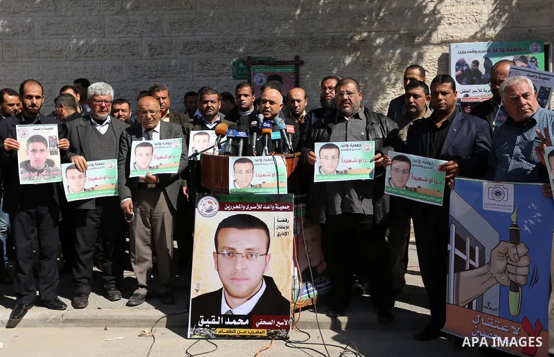 Palestinians hold placards during a protest to show solidarity with Palestinian prisoners held in Israeli Jails, in front of Red cross office in Gaza city, on February 21, 2017. Photo by Ashraf Amra