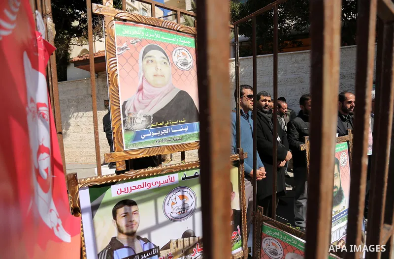Palestinians hold placards during a protest to show solidarity with Palestinian prisoners held in Israeli Jails, in front of Red cross office in Gaza city, on February 21, 2017. Photo by Ashraf Amra
