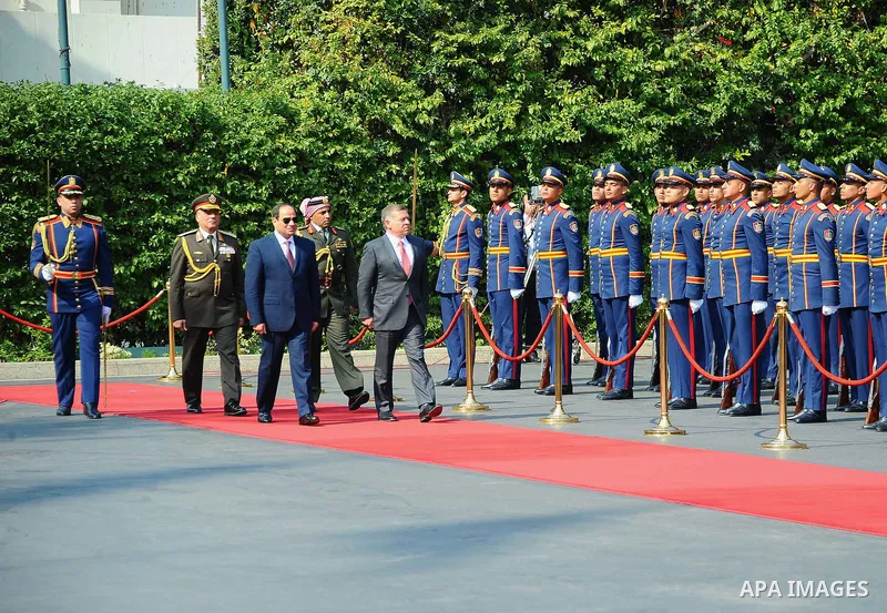 A handout picture released by the Jordanian Royal Palace on February 21, 2017, shows Jordan's King Abdullah II (C) reviewing the honour guard alongside Egyptian President Abdel Fattah al-Sisi during a meeting in Cairo. P...