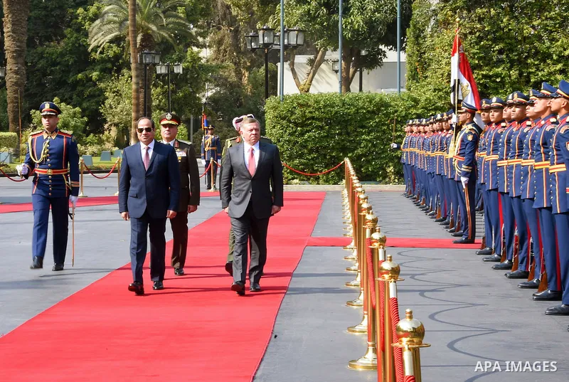A handout picture released by the Jordanian Royal Palace on February 21, 2017, shows Jordan's King Abdullah II (C) reviewing the honour guard alongside Egyptian President Abdel Fattah al-Sisi during a meeting in Cairo. P...