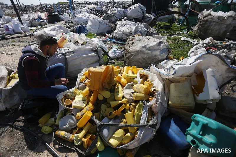 A Palestinian man collects plastics and metals from a pile of waste in Gaza city, February 22, 2017. Workers collect the household recyclables, metals and plastic from landfill and garbage to sell to the local factories....