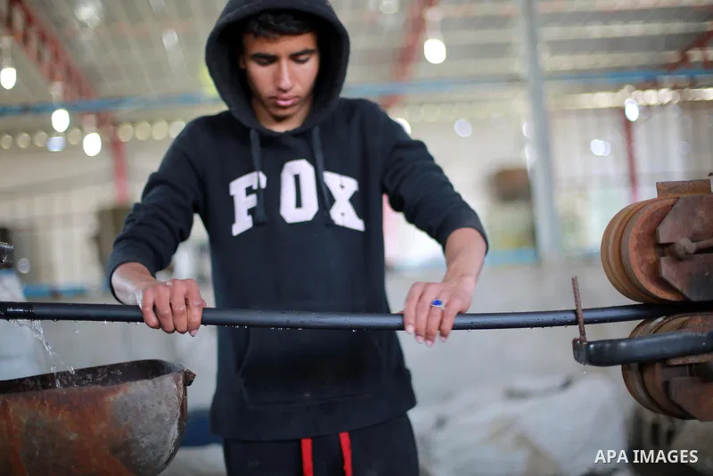 A Palestinian worker reuses plastics and metals to produce water hoses at a factory, in Gaza city, February 22, 2017. Workers collect the household recyclables, metals and plastic from landfill and garbage to sell to the...