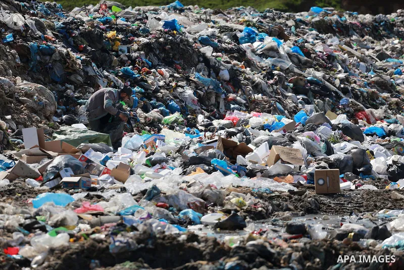 A Palestinian man collects plastics and metals from a pile of waste in Gaza city, February 22, 2017. Workers collect the household recyclables, metals and plastic from landfill and garbage to sell to the local factories....