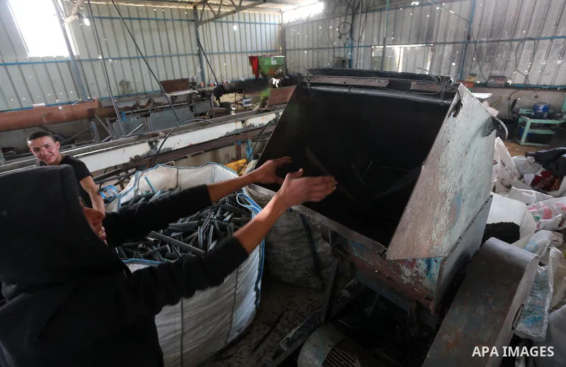 A Palestinian worker reuses plastics and metals to produce water hoses at a factory, in Gaza city, February 22, 2017. Workers collect the household recyclables, metals and plastic from landfill and garbage to sell to the...