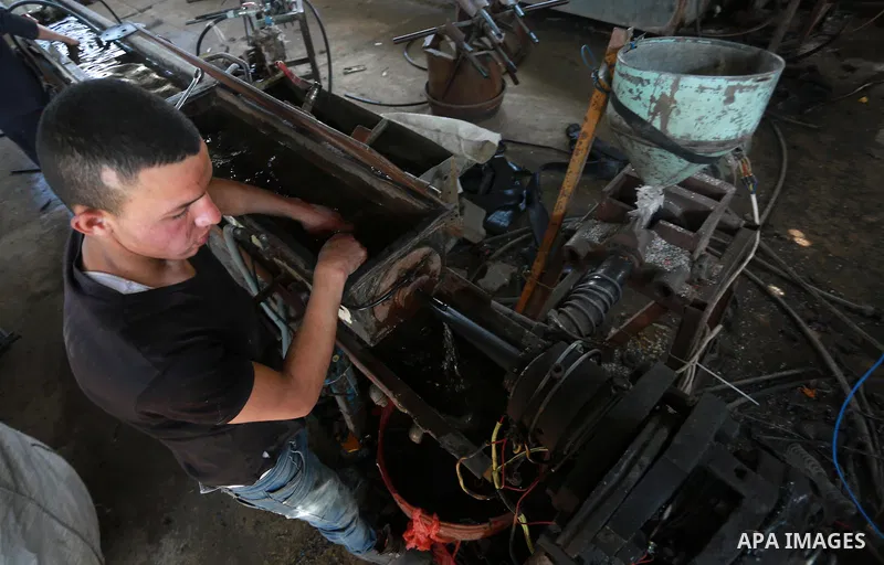 A Palestinian worker reuses plastics and metals to produce water hoses at a factory, in Gaza city, February 22, 2017. Workers collect the household recyclables, metals and plastic from landfill and garbage to sell to the...