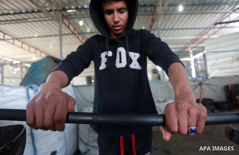 A Palestinian worker reuses plastics and metals to produce water hoses at a factory, in Gaza city, February 22, 2017. Workers collect the household recyclables, metals and plastic from landfill and garbage to sell to the...