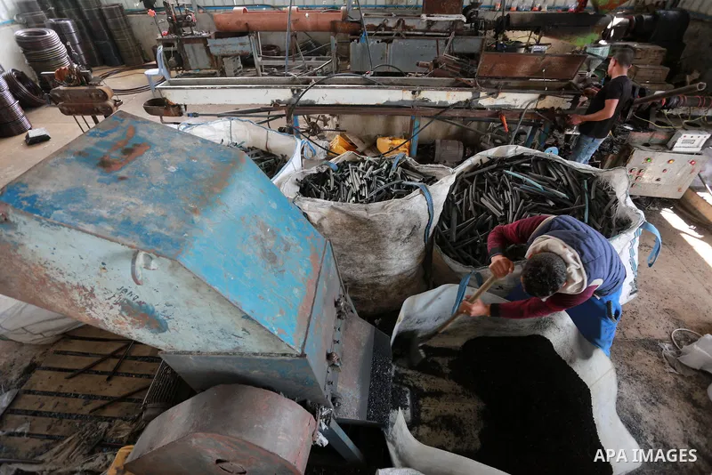 A Palestinian worker reuses plastics and metals to produce water hoses at a factory, in Gaza city, February 22, 2017. Workers collect the household recyclables, metals and plastic from landfill and garbage to sell to the...