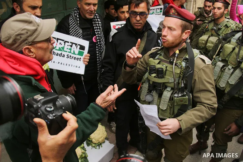 A Palestinian protester argues with a member of Israeli security forces during a demonstration against the closure of Shuhada street, on the 23rd anniversary of the closure, on February 22, 2017 in the West Bank city of...