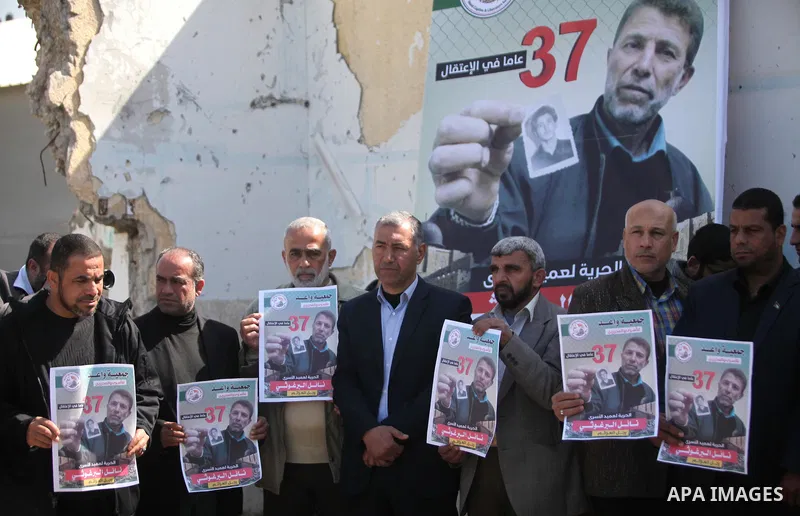 Palestinians hold placards during a protest to show solidarity with Palestinian prisoner Nael Barghouthi, held in Israeli Jails, in Gaza city, on February 23, 2017. Photo by Ashraf Amra