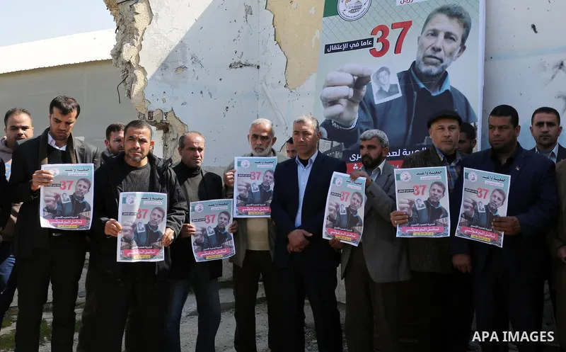 Palestinians hold placards during a protest to show solidarity with Palestinian prisoner Nael Barghouthi, held in Israeli Jails, in Gaza city, on February 23, 2017. Photo by Ashraf Amra