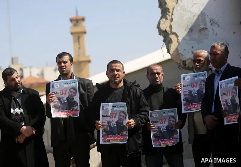 Palestinians hold placards during a protest to show solidarity with Palestinian prisoner Nael Barghouthi, held in Israeli Jails, in Gaza city, on February 23, 2017. Photo by Ashraf Amra