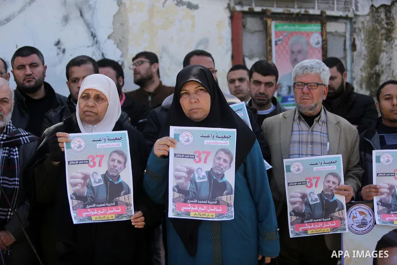 Palestinians hold placards during a protest to show solidarity with Palestinian prisoner Nael Barghouthi, held in Israeli Jails, in Gaza city, on February 23, 2017. Photo by Ashraf Amra