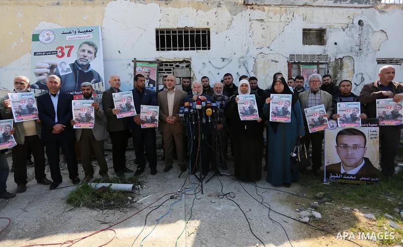 Palestinians hold placards during a protest to show solidarity with Palestinian prisoner Nael Barghouthi, held in Israeli Jails, in Gaza city, on February 23, 2017. Photo by Ashraf Amra