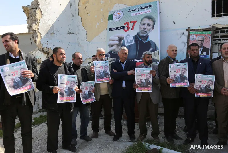 Palestinians hold placards during a protest to show solidarity with Palestinian prisoner Nael Barghouthi, held in Israeli Jails, in Gaza city, on February 23, 2017. Photo by Ashraf Amra