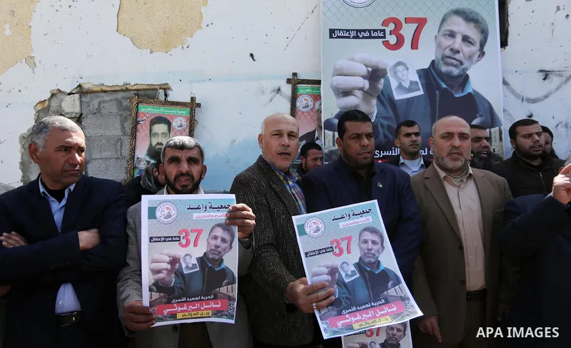 Palestinians hold placards during a protest to show solidarity with Palestinian prisoner Nael Barghouthi, held in Israeli Jails, in Gaza city, on February 23, 2017. Photo by Ashraf Amra