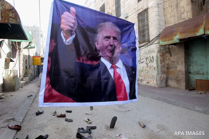 A general view shows old shoes being thrown by Palestinian demonstrator at a poster of US President Donald Trump as they protest against his support of Israel and demand for the Israeli army to re-open Shuhada Street whi...