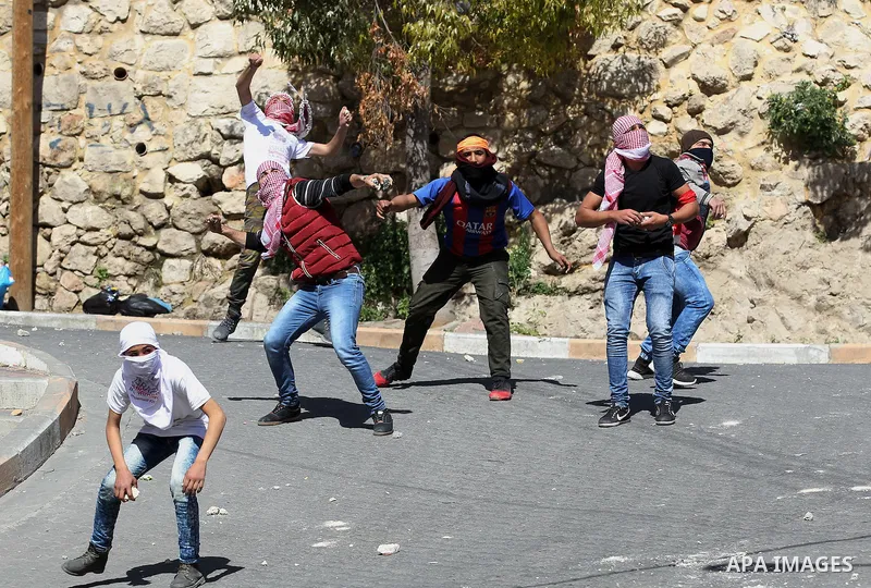 Palestinian protesters clash with Israeli security forces, during a demonstration calling for the opening of Shuhada Street, which is largely closed off to Palestinians, in the West Bank city of Hebron, coinciding with t...