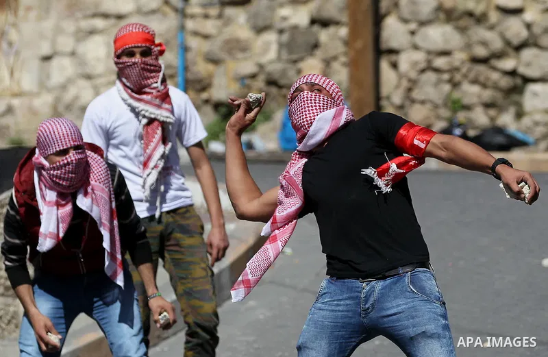 Palestinian protesters clash with Israeli security forces, during a demonstration calling for the opening of Shuhada Street, which is largely closed off to Palestinians, in the West Bank city of Hebron, coinciding with t...