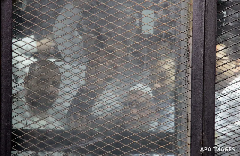 Egyptian Muslim Brotherhood defendants are seen behind bars during their trial, in a case known in media as "Rabaa Operations Room", in Cairo, on February 25, 2017. Photo by Amr Sayed