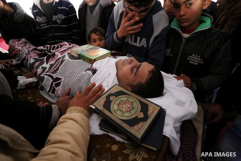 Palestinians mourn around the body of Palestinian Abdullah Alnamula, 23, who died after inhaling toxic gas inside the tunnel along the border between the Gaza Strip and Egypt during his funeral in Rafah in the southern G...