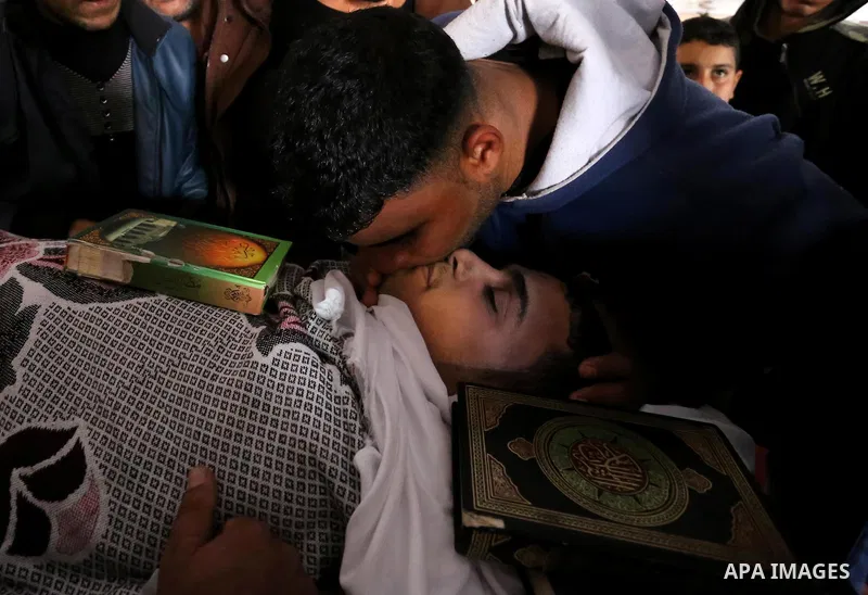 Palestinians mourn around the body of Palestinian Abdullah Alnamula, 23, who died after inhaling toxic gas inside the tunnel along the border between the Gaza Strip and Egypt during his funeral in Rafah in the southern G...