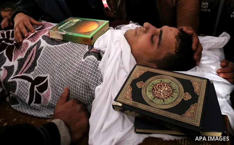 Palestinians mourn around the body of Palestinian Abdullah Alnamula, 23, who died after inhaling toxic gas inside the tunnel along the border between the Gaza Strip and Egypt during his funeral in Rafah in the southern G...