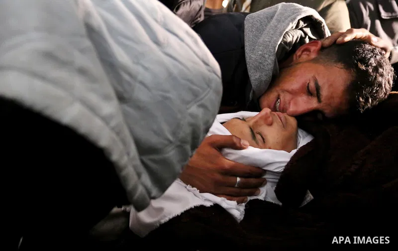 Palestinians mourn around the body of Palestinian Obeid Soufi, 25, who died after inhaling toxic gas inside the tunnel along the border between the Gaza Strip and Egypt during his funeral in Rafah in the southern Gaza st...