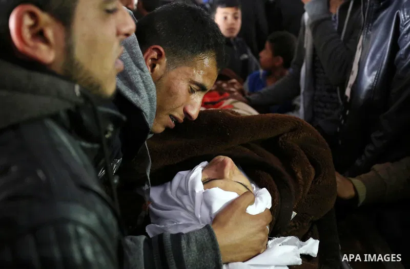 Palestinians mourn around the body of Palestinian Obeid Soufi, 25, who died after inhaling toxic gas inside the tunnel along the border between the Gaza Strip and Egypt during his funeral in Rafah in the southern Gaza st...
