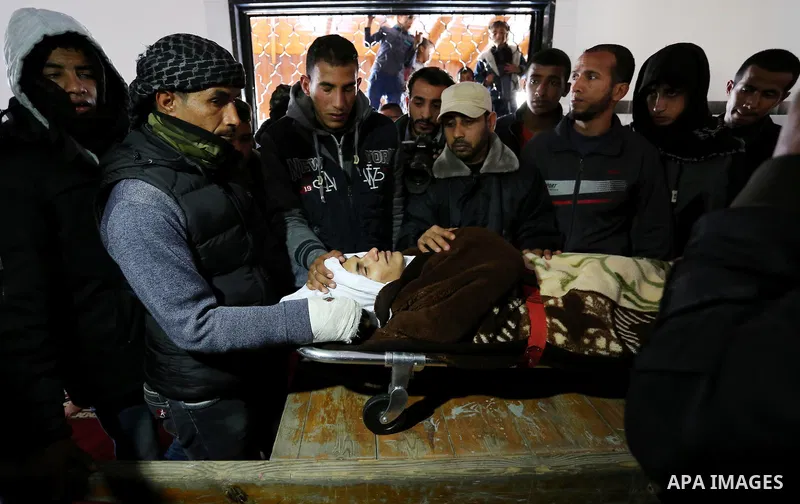 Palestinians mourn around the body of Palestinian Obeid Soufi, 25, who died after inhaling toxic gas inside the tunnel along the border between the Gaza Strip and Egypt during his funeral in Rafah in the southern Gaza st...