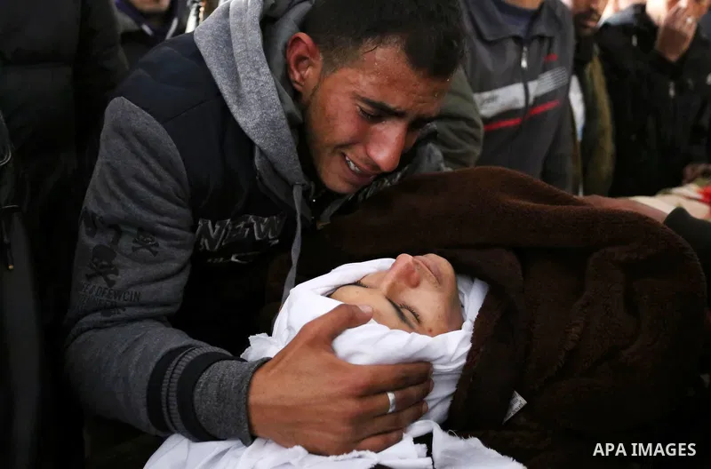 Palestinians mourn around the body of Palestinian Obeid Soufi, 25, who died after inhaling toxic gas inside the tunnel along the border between the Gaza Strip and Egypt during his funeral in Rafah in the southern Gaza st...